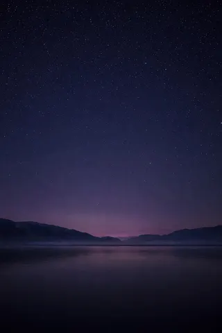 A dark lake under a starry night sky
